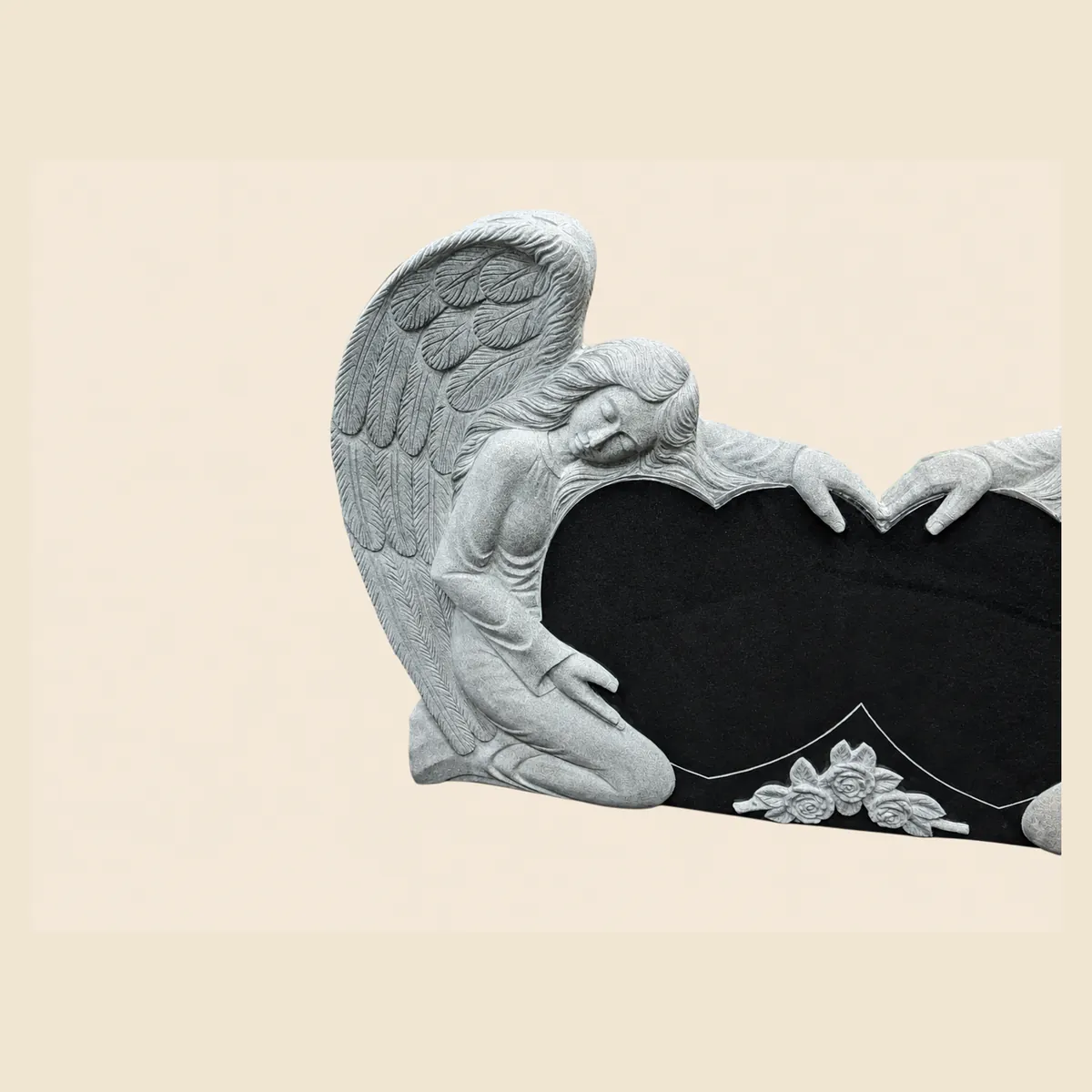 Kneeling angel embracing a polished black double heart with carved roses