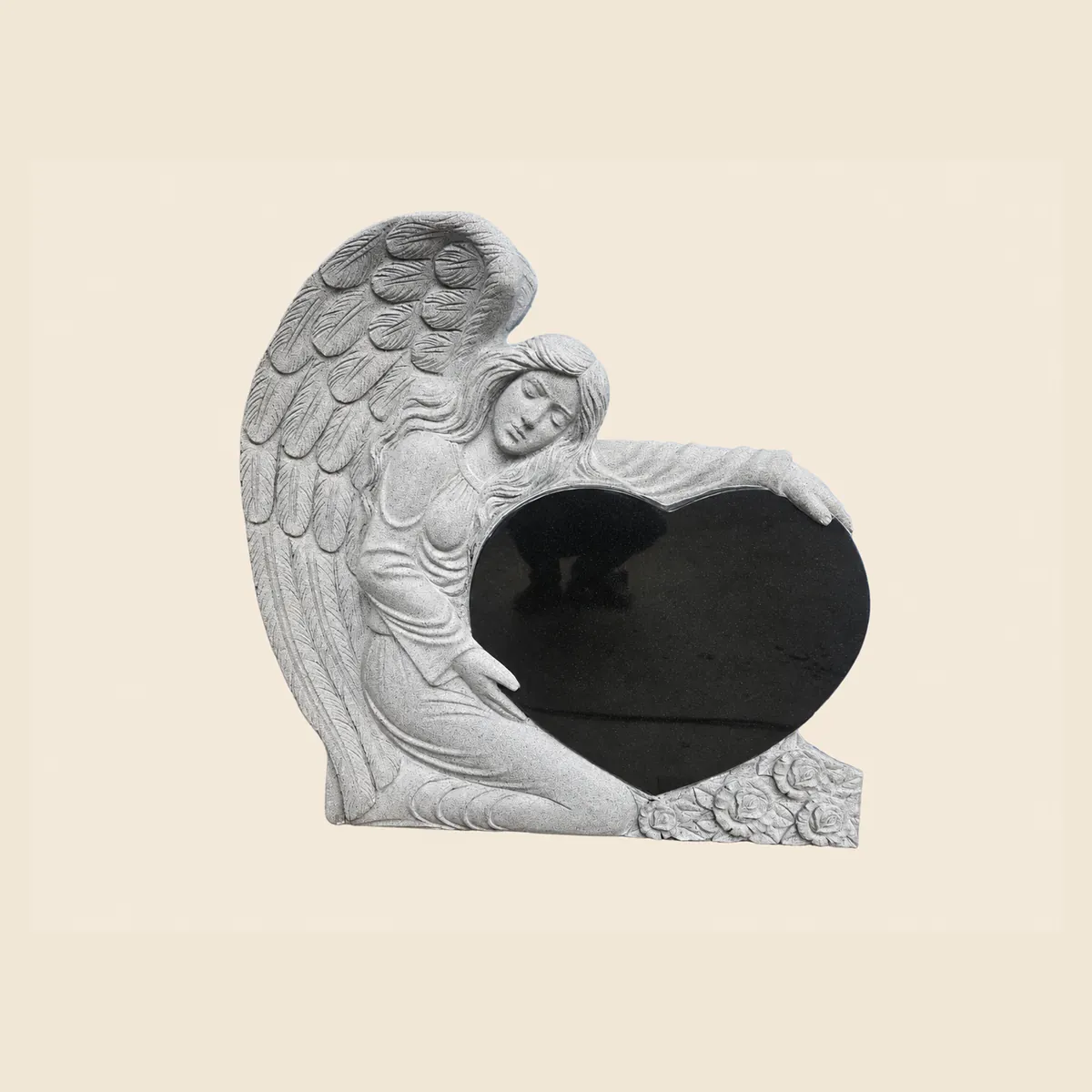 Hand-carved kneeling angel holding a polished black granite heart