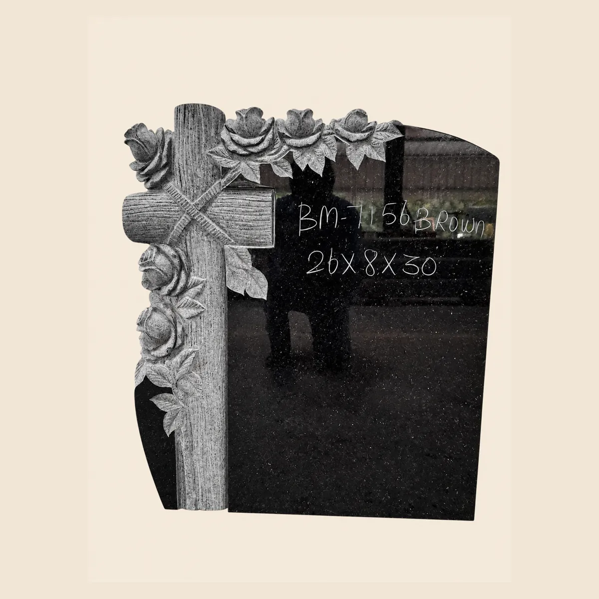 Black granite upright with a hand-carved cross wrapped in roses