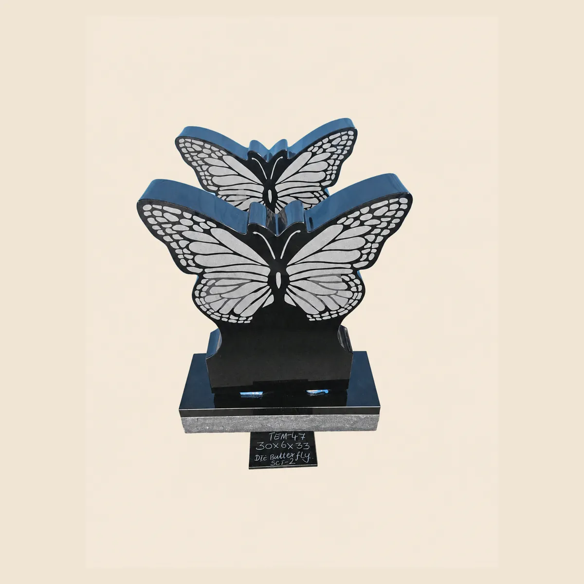Black granite twin-butterfly memorial with laser-etched wings on a stepped base