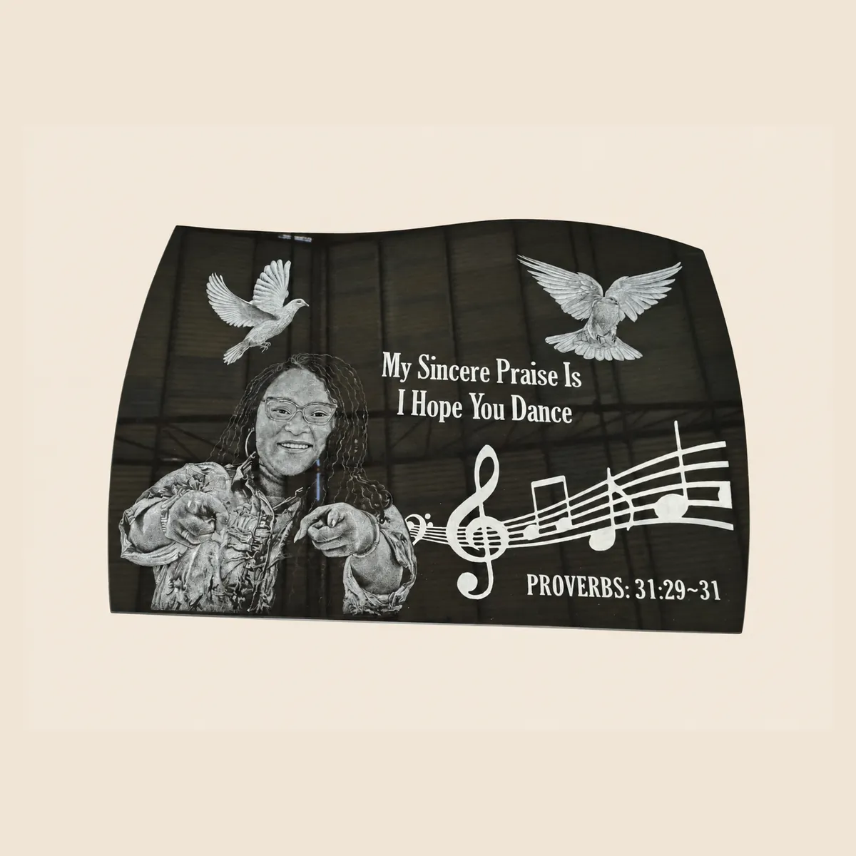 Laser-etched portrait with doves and musical notes on a black granite serpentine-top tablet